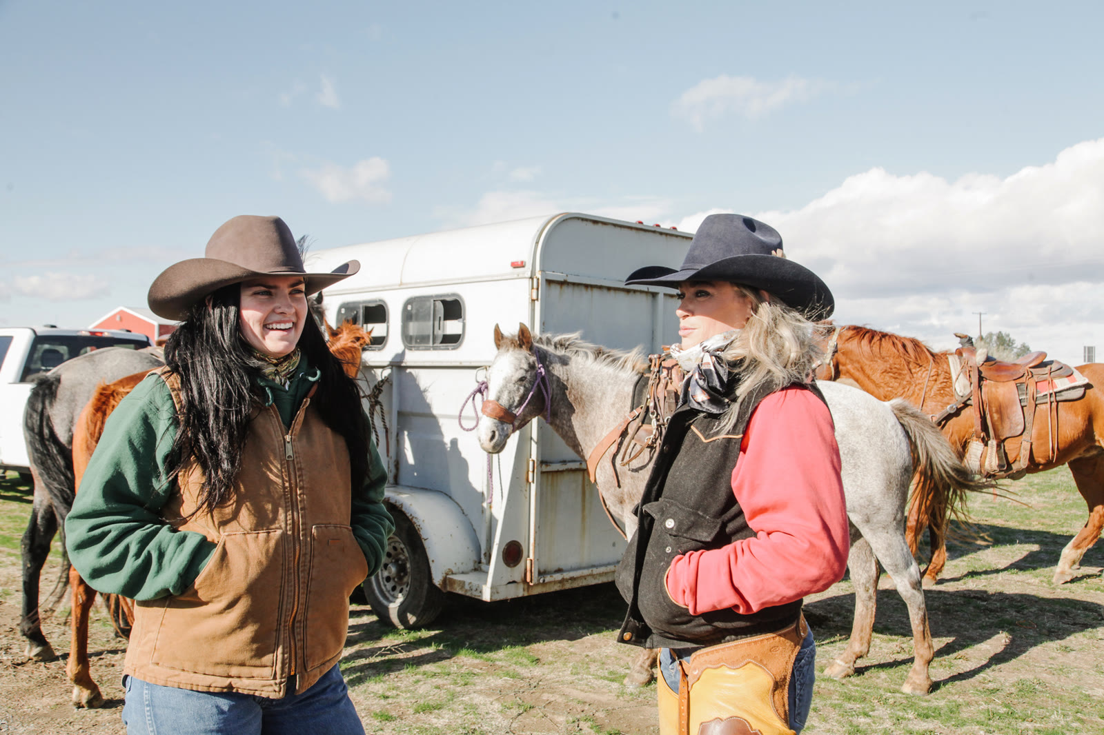 Two riders talking beside a horse trailer